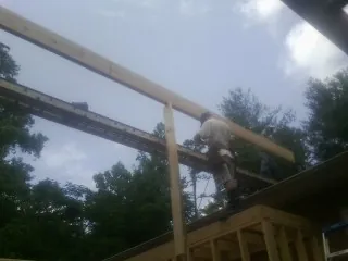 Carpenter setting a ridge beam over a new addition frame — Ice Dam Removal by Roofing Brothers in Pleasant Plains
