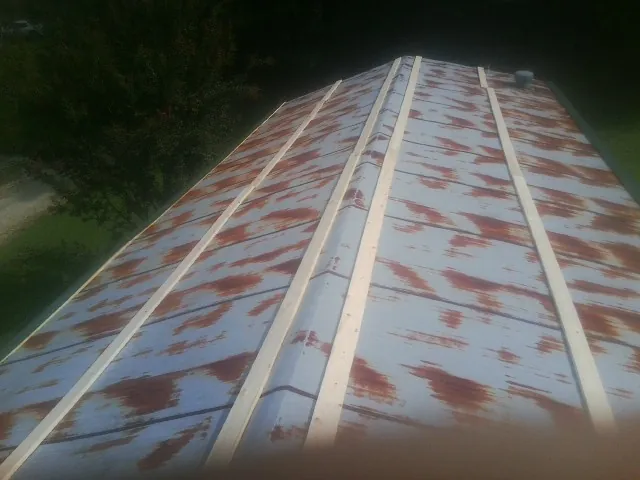 Rusted metal roof panels with new wood purlins before replacement — Storm Damage Roof Repair in Pleasant Plains by Roofing Brothers