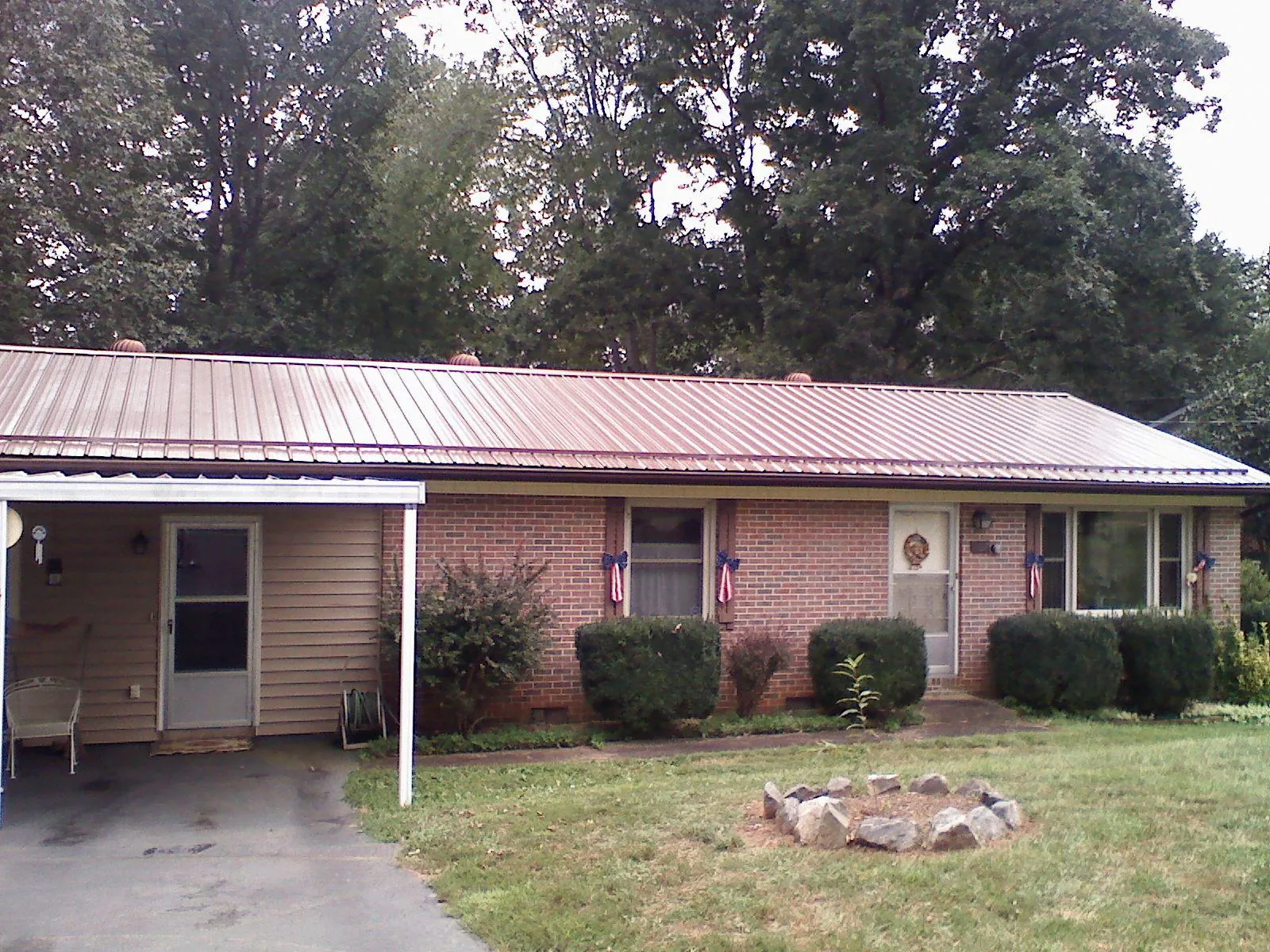 Bronze metal roof and carport on a brick ranch home — Roof Repair work by our crew in Pleasant Plains